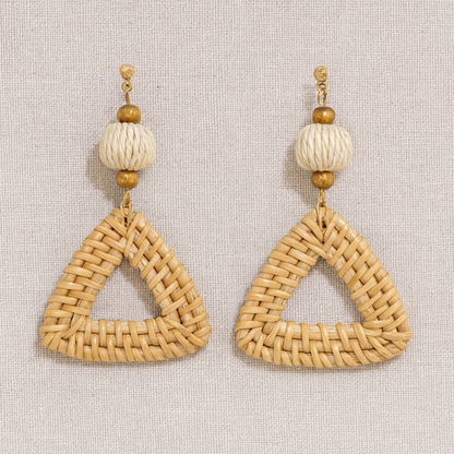 Pair of triangular rattan weave earrings with natural beads on neutral linen background.