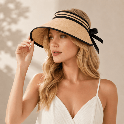 Woman styling a light coffee wide brim straw sun visor with black edging in a natural summer setting