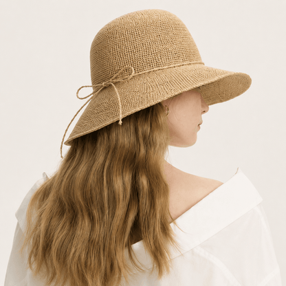 Back side view of woman wearing a natural woven straw sun hat with wide brim
