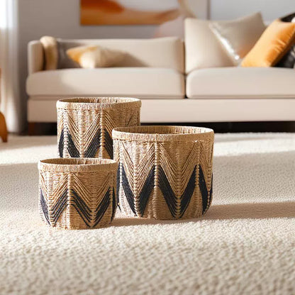 Set of three woven paper rope storage baskets in natural and black zigzag design, displayed in a modern living room.