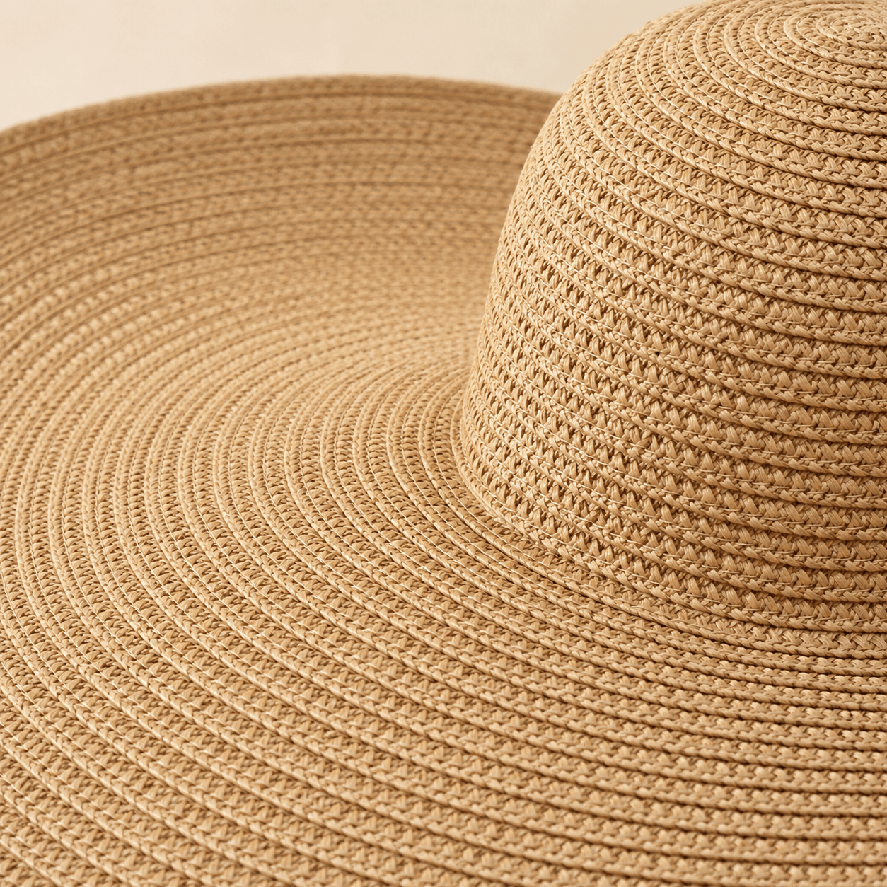 Close up of the woven texture and crown detail of an oversized straw sun hat