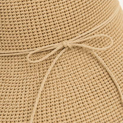 Close-up of woven straw texture and slim bow tie detail on a beige sun hat